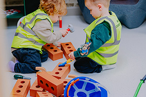 two young boys playing builders with foam bricks