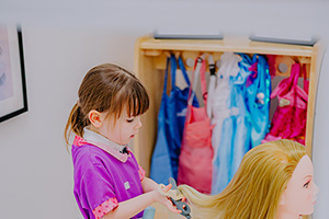 young girl playing hairdressers with a dolls head
